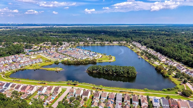 aerial view of property's location featuring nearby suburban area, a heavily wooded area, and a large body of water