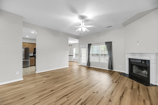 unfurnished living room featuring a ceiling fan, light wood-style flooring, a fireplace, recessed lighting, and baseboards