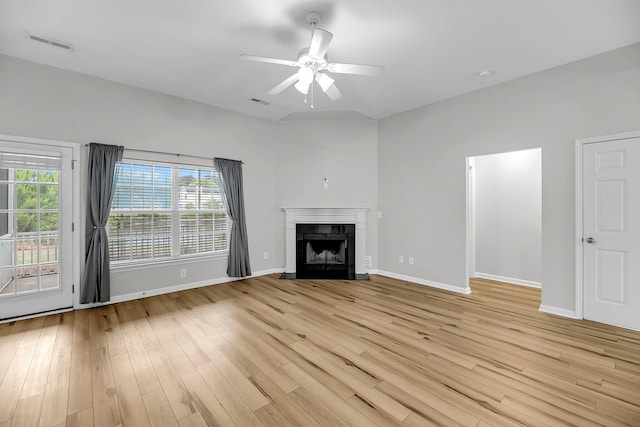 unfurnished living room featuring baseboards, ceiling fan, light wood-style floors, and a fireplace