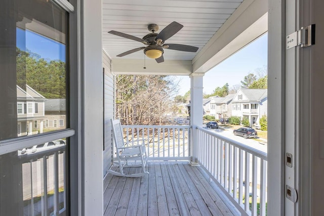 wooden deck featuring a residential view and a ceiling fan