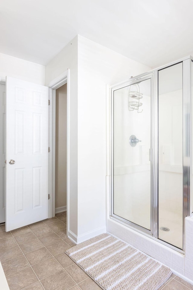 full bath with a stall shower and baseboards