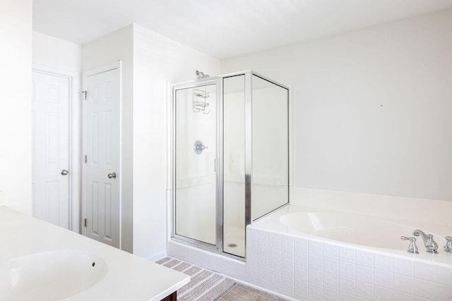 bathroom with a stall shower, tile patterned flooring, a garden tub, and vanity