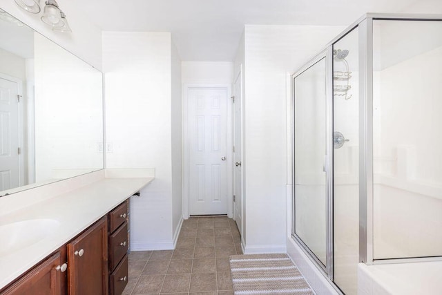 bathroom featuring tile patterned floors, a shower stall, baseboards, and vanity