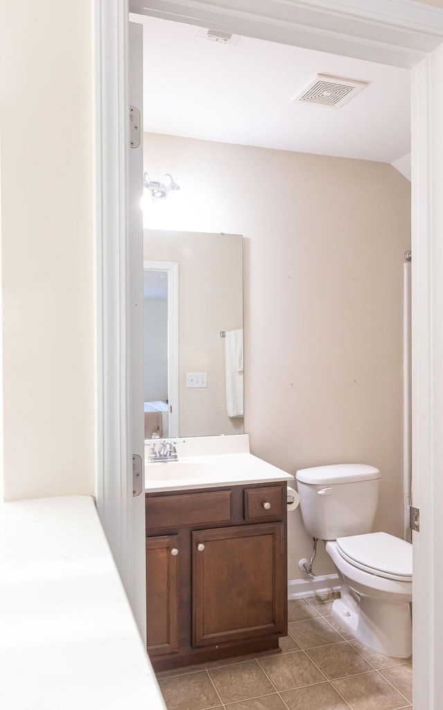 bathroom with toilet, vanity, visible vents, and tile patterned floors