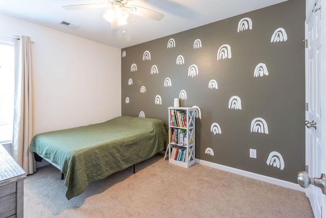 bedroom with visible vents, a ceiling fan, an accent wall, carpet flooring, and baseboards