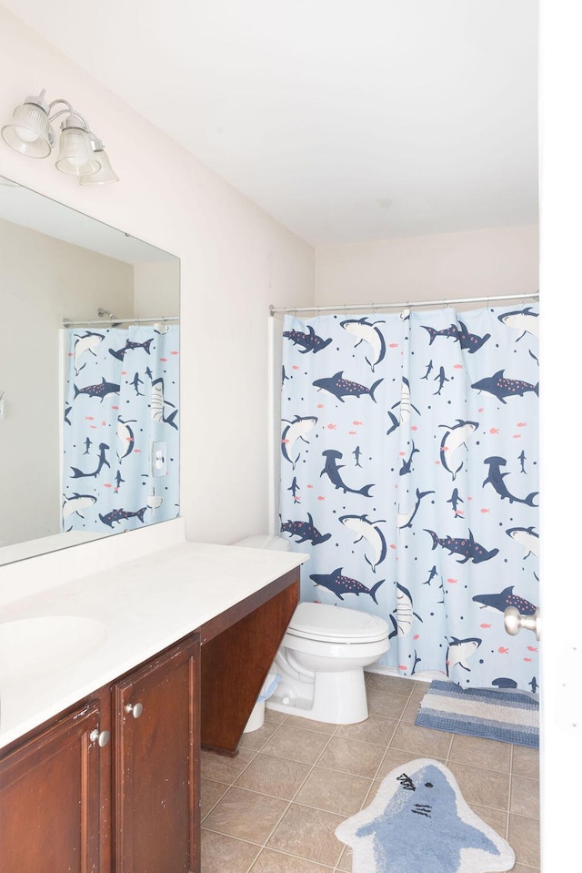 bathroom with toilet, a shower with shower curtain, vanity, and tile patterned floors