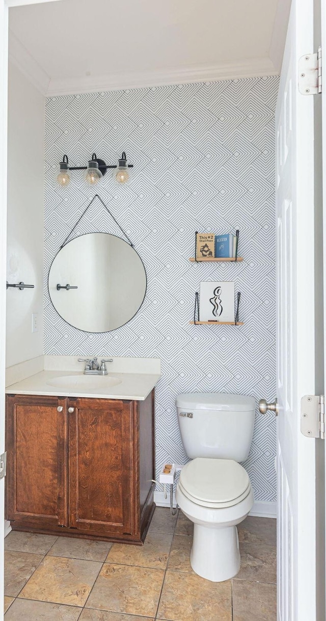 bathroom with ornamental molding, vanity, toilet, and wallpapered walls