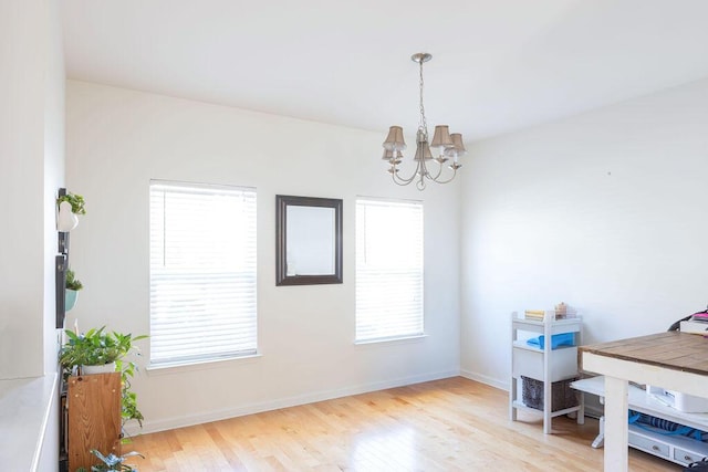 interior space with an inviting chandelier, baseboards, and wood finished floors