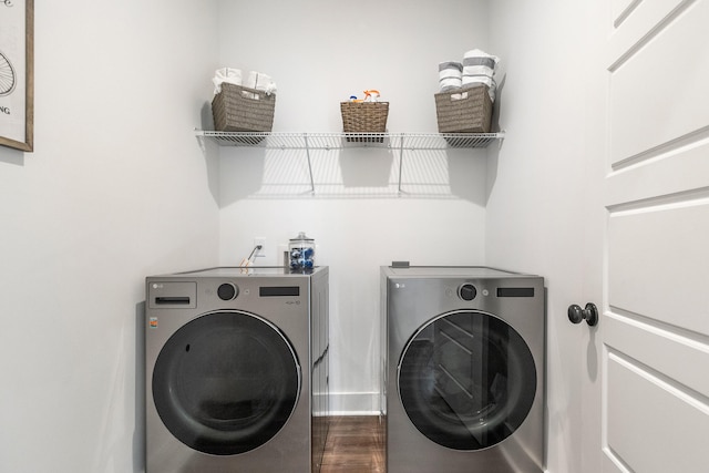 clothes washing area featuring washer and clothes dryer and dark hardwood / wood-style flooring