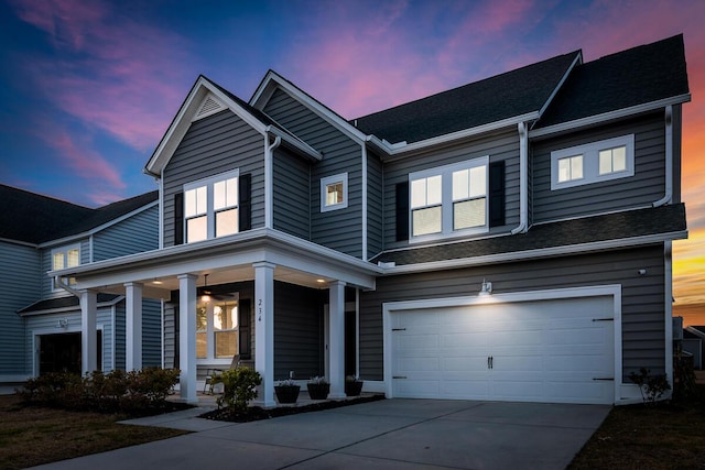 view of front of house with a garage, driveway, and a porch