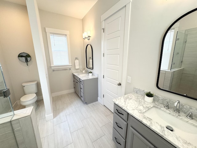 bathroom with two vanities, a sink, a shower stall, and baseboards