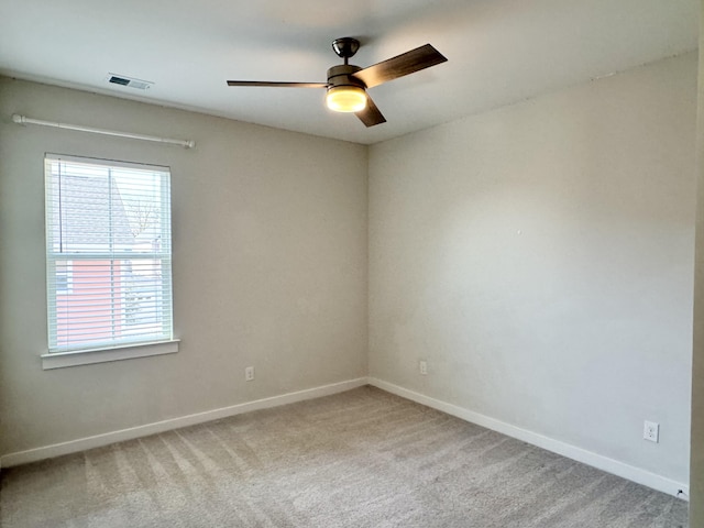 spare room with ceiling fan, visible vents, baseboards, and carpet flooring