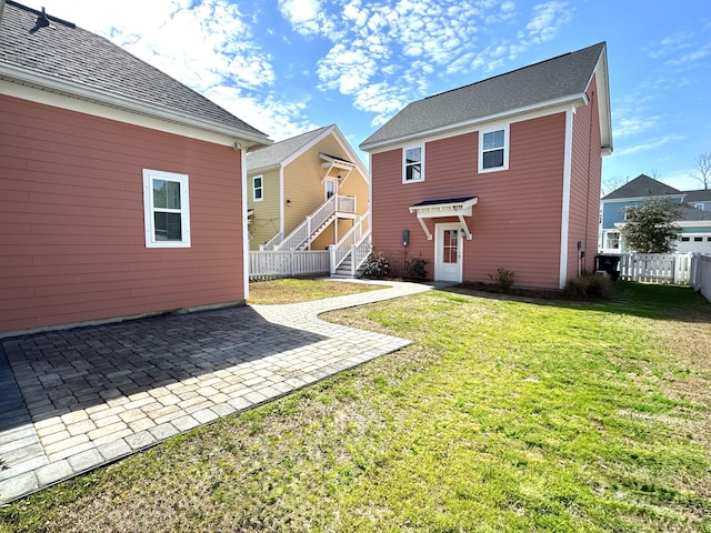 rear view of house with a yard, a patio area, and fence