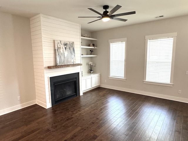 unfurnished living room featuring baseboards, visible vents, a ceiling fan, dark wood-style flooring, and a fireplace