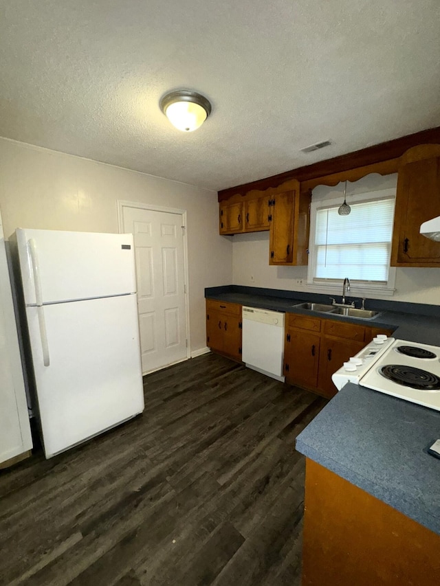 kitchen with a textured ceiling, white appliances, dark wood-type flooring, and sink