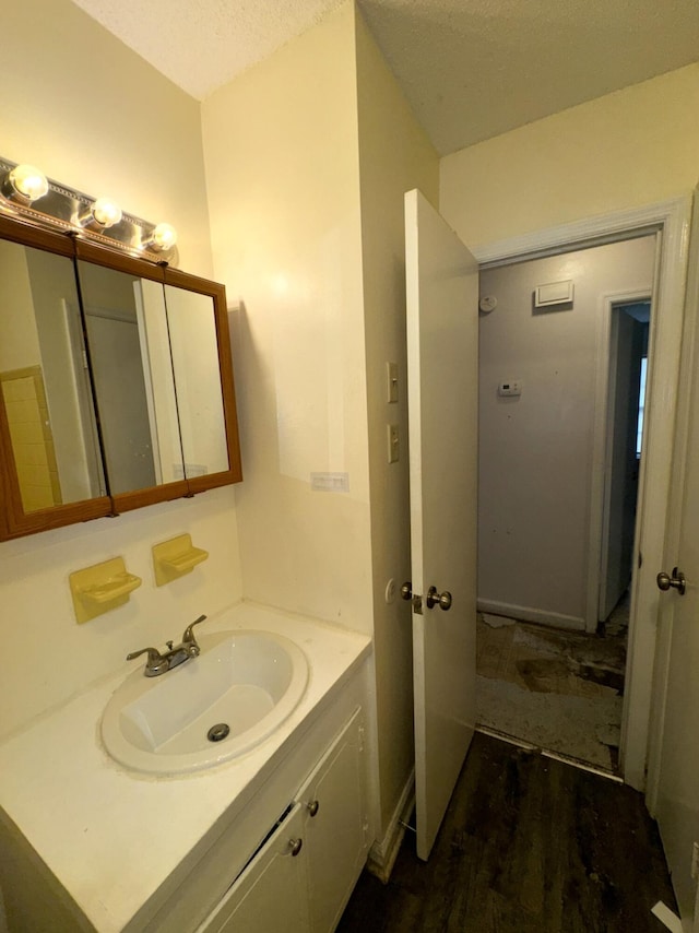 bathroom with vanity, hardwood / wood-style floors, and a textured ceiling