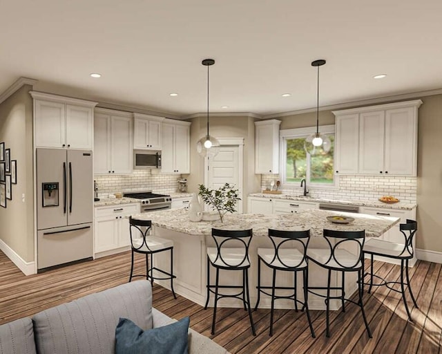 kitchen featuring a kitchen island, white cabinets, appliances with stainless steel finishes, and decorative light fixtures