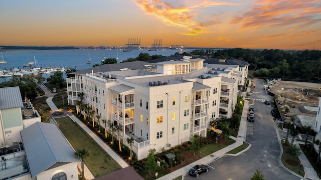 aerial view at dusk featuring a water view