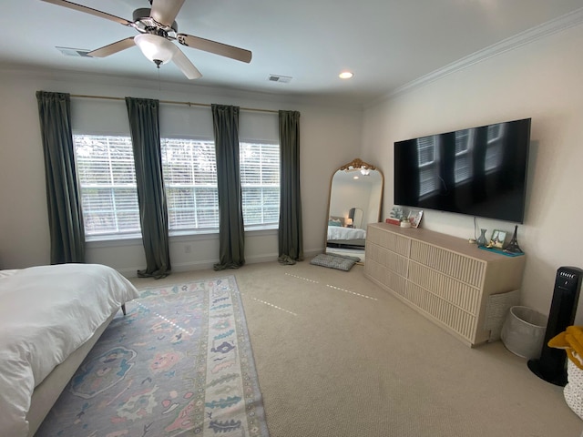 carpeted bedroom with visible vents, crown molding, baseboards, and ceiling fan