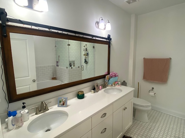 bathroom featuring double vanity, a sink, toilet, and a shower stall