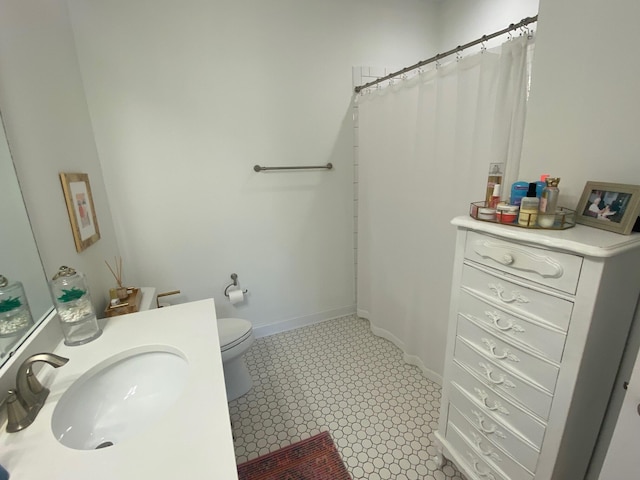 bathroom with a shower with curtain, baseboards, a sink, and toilet