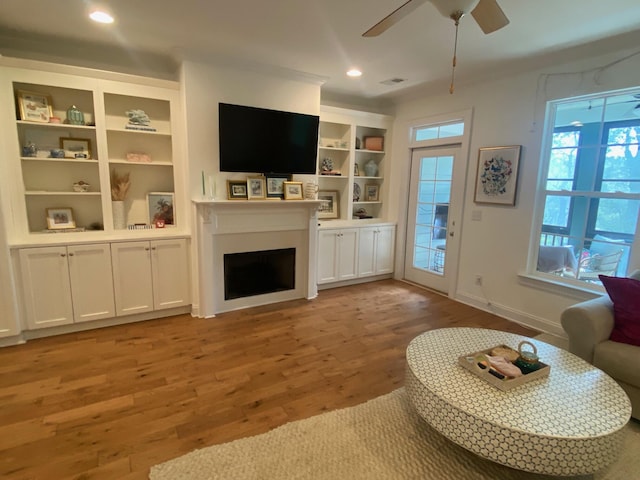 living area with recessed lighting, a fireplace, a ceiling fan, visible vents, and light wood-style floors