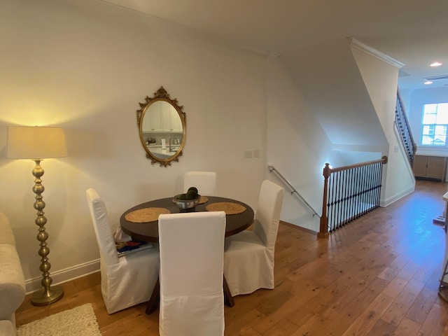 dining area with visible vents, crown molding, baseboards, and wood finished floors