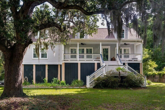 rear view of property with ceiling fan, a porch, and a yard