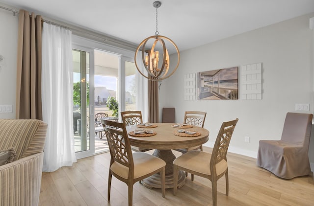 dining space featuring light hardwood / wood-style floors and a chandelier