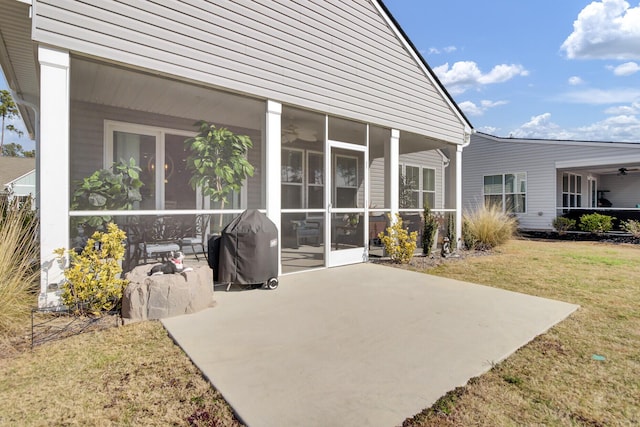 back of property featuring a yard, a patio area, and a sunroom