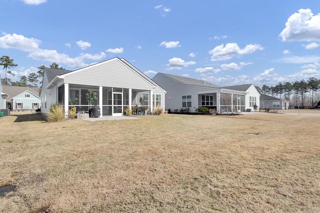 rear view of house with a lawn and a sunroom