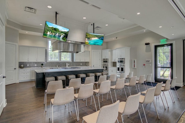 kitchen featuring a towering ceiling, a center island, and white cabinets