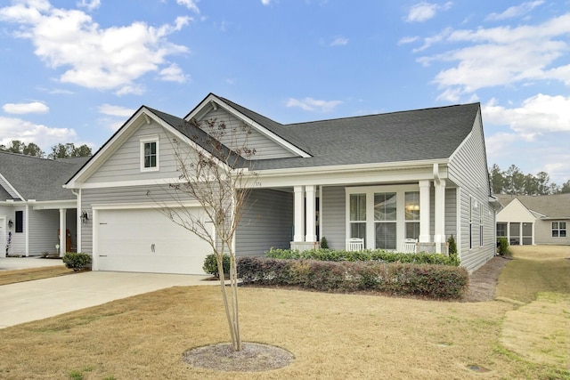 view of front of property with a garage, a porch, and a front yard