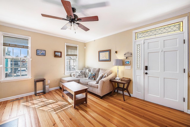 living room featuring visible vents, baseboards, light wood-style floors, and ornamental molding