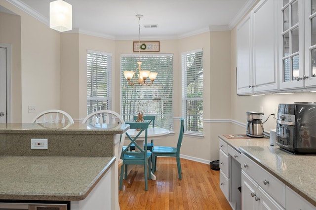 dining room with light wood finished floors, a chandelier, baseboards, and crown molding