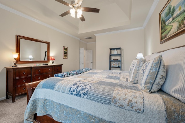 carpeted bedroom featuring a raised ceiling, ornamental molding, and a ceiling fan