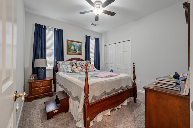 carpeted bedroom featuring a closet, baseboards, and ceiling fan