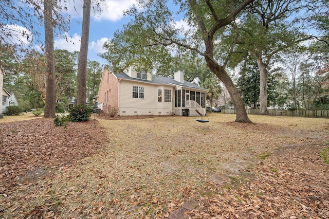 view of front of house featuring a sunroom, a chimney, crawl space, and fence