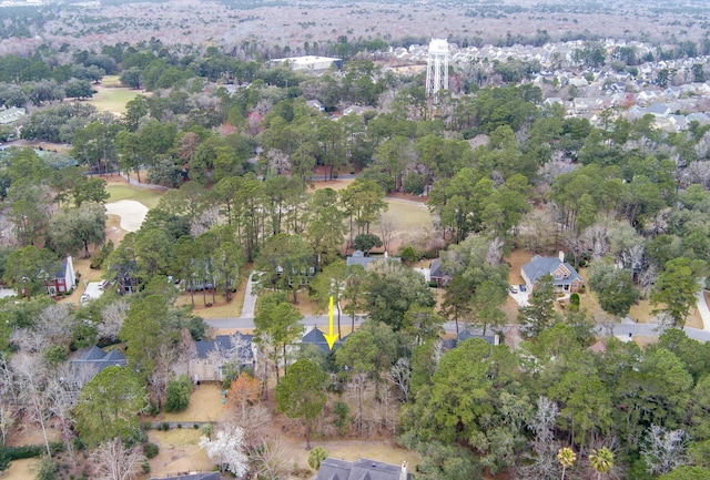aerial view of property and surrounding area featuring a tree filled landscape