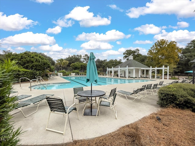 community pool featuring a patio area and view of scattered trees