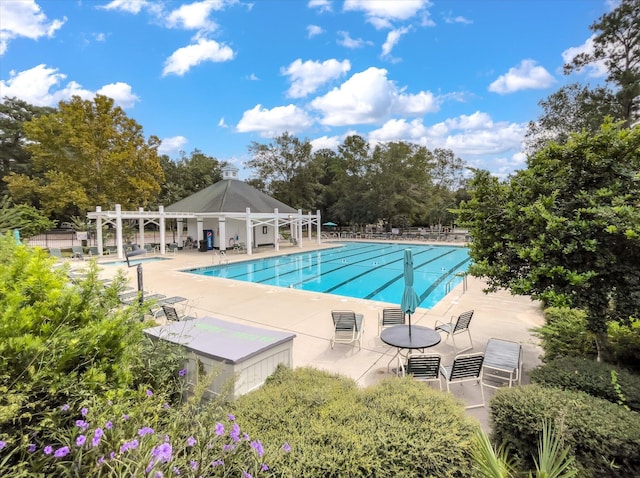 community pool featuring a patio, a pergola, fence, and view of scattered trees