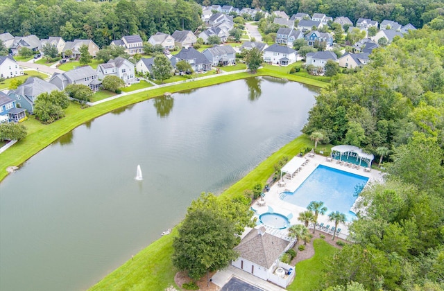 aerial view of residential area with a pool and a large body of water