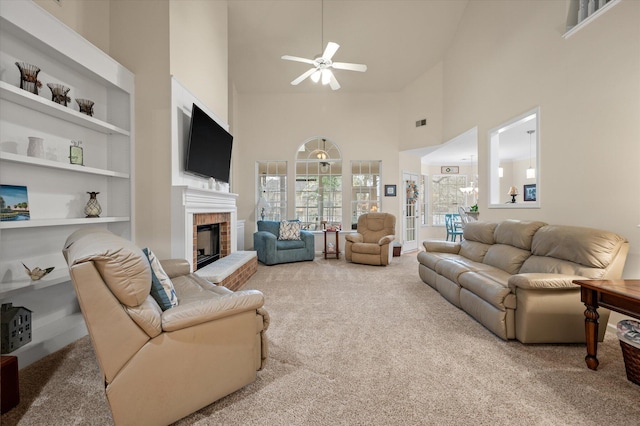 living area with high vaulted ceiling, ceiling fan, carpet flooring, a fireplace, and built in features
