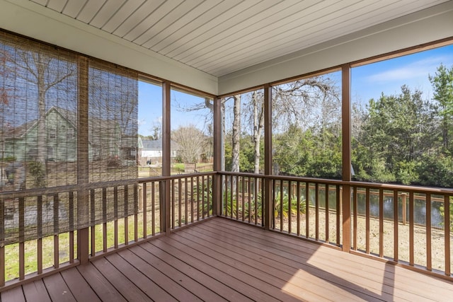 unfurnished sunroom featuring a wealth of natural light and a water view