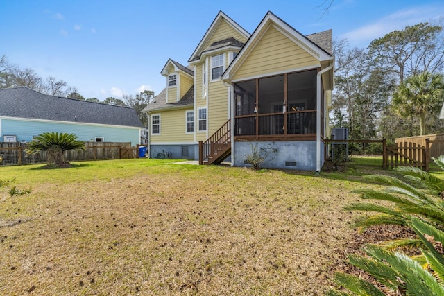 back of property featuring crawl space, a lawn, a fenced backyard, and a sunroom