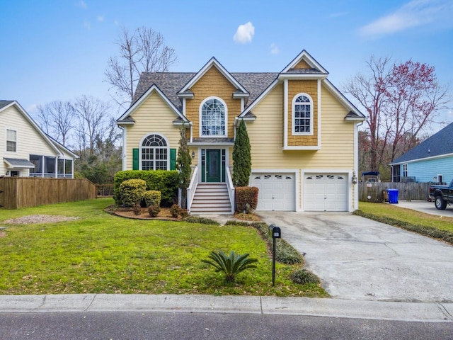 traditional-style house featuring driveway, a front lawn, fence, a shingled roof, and a garage