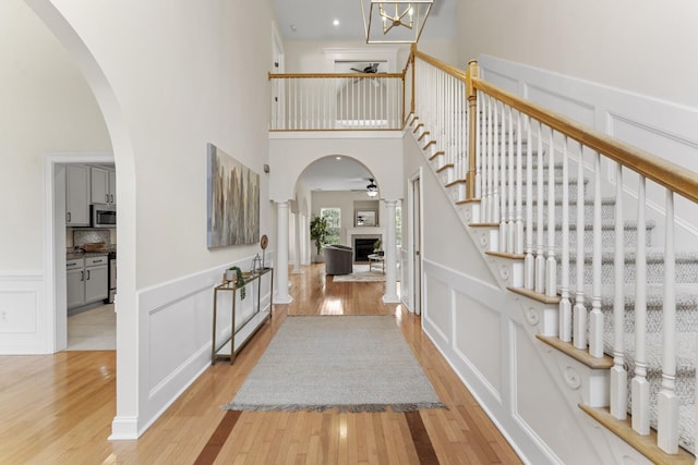 foyer featuring a fireplace, a decorative wall, and light wood-style floors