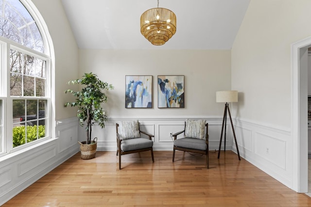 living area featuring plenty of natural light, wood finished floors, and vaulted ceiling