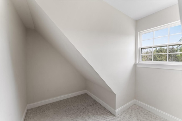 additional living space with vaulted ceiling, carpet flooring, and baseboards