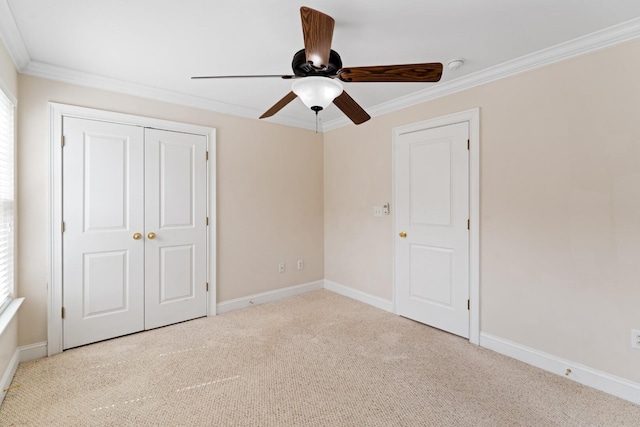 unfurnished bedroom with crown molding, ceiling fan, baseboards, carpet, and a closet